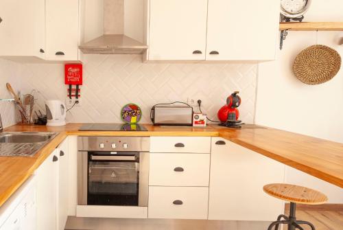 a kitchen with white cabinets and a stove top oven at Candelária House in Candelária