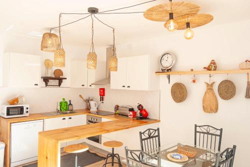 a kitchen with white cabinets and a table and chairs at Candelária House in Candelária
