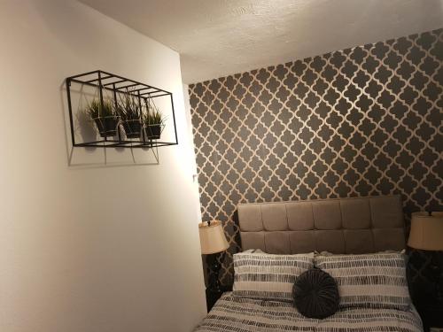 um quarto com uma cama com dois vasos de plantas na parede em Quantock Lodge Studio 2 em Strood