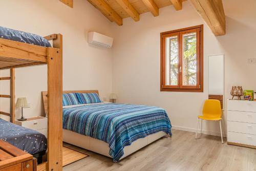 a bedroom with a bunk bed and a yellow chair at Relais des Roches in Sona