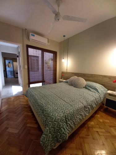 um quarto com uma cama com um edredão verde em Josefa - Departamento con terraza y parrila em Mendoza