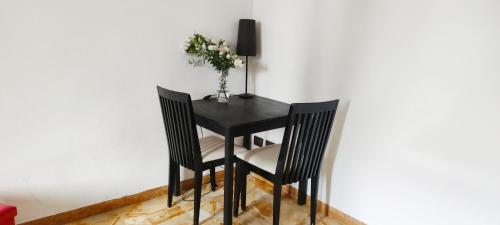 una mesa negra con dos sillas y un jarrón de flores en Urban central Florence, en Florencia