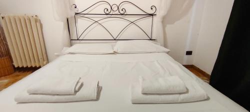 un letto bianco con testiera metallica e cuscini bianchi di Urban central Florence a Firenze