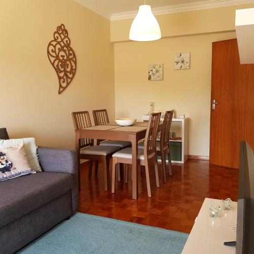 a living room with a table and chairs and a couch at B Apartamentos in Viana do Castelo