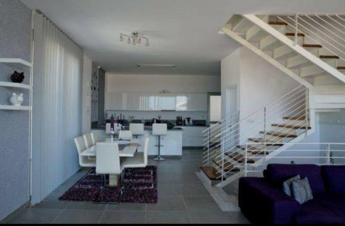 a kitchen and a living room with a dining table and a staircase at Leonidas VILLA in Paphos City