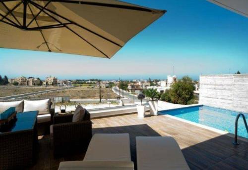 a living room with a swimming pool and a patio at Leonidas VILLA in Paphos City