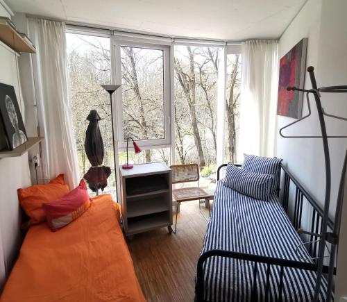 uma sala de estar com um sofá, uma secretária e uma janela em Ferienwohnung im Turm Bellevue mit 3 Schlafzimmern em Sachsenheim