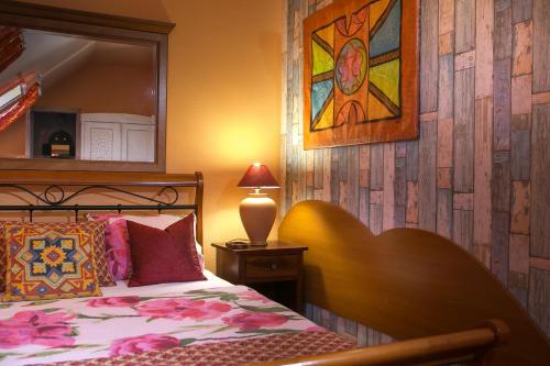 a bedroom with a bed and a mirror and a lamp at Green Park Villa in Eger