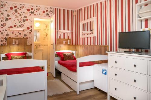 a small bedroom with two beds and a tv at Green Park Villa in Eger