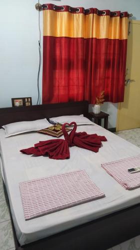 - un lit avec deux parasols rouges au-dessus dans l'établissement Ahobilaa Homestay, à Tiruchirappalli