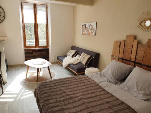 1 dormitorio con cama, sofá y mesa en studio vllage, en Entrecasteaux