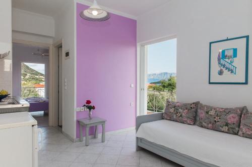 - un salon avec un mur violet et un canapé dans l'établissement Dionysos Studios Apartments Nidri Lefkas, à Nydri