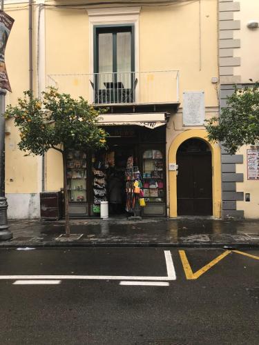 a store on the side of a building with a woman standing in the doorway at Rosa Magra Guest House in Sorrento