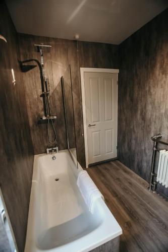 a bathroom with a white tub and a shower at PARKER St by Prestige Properties SA in Barrow in Furness