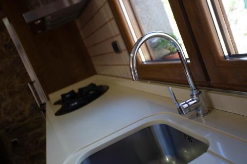 a kitchen sink with a faucet next to a window at Casal Rivas in Muxia