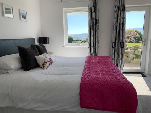a bedroom with a large bed with a large window at The Bungalows Guesthouse in Threlkeld
