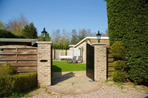 a entrance to a house with a brick gate at Bungalow between Amsterdam and Haarlem with sauna in Vijfhuizen