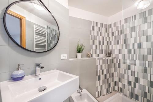 La salle de bains blanche est pourvue d'un lavabo et d'un miroir. dans l'établissement il Mare di Ada:seaside apartament in Riomaggiore, à Riomaggiore