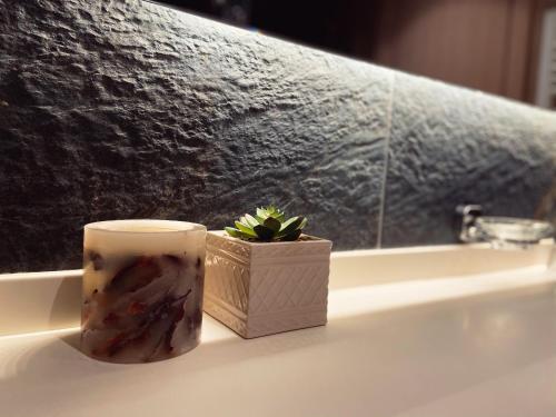 a candle sitting on a bathroom counter next to a window at Teddy Apartman Kula Konaci in Kopaonik