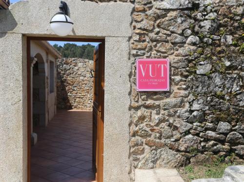 a sign on the side of a stone building with a door at Casal Pedrajás in Muxia