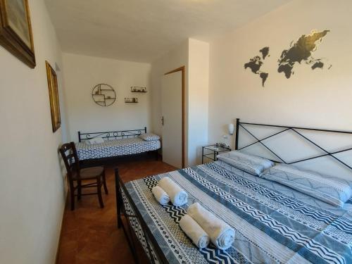 Bed & Bike Casa dei Papi في بورتوفيرّايو: غرفة نوم بسريرين توأم وكرسي
