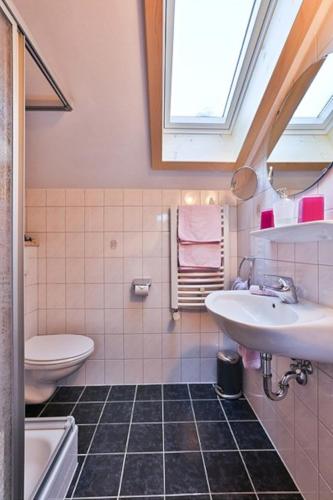 a bathroom with a sink and a toilet and a window at Ferienwohnung Wurm in Schönau am Königssee