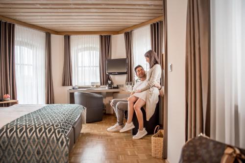 a man and a woman sitting in a hotel room at Hotel Restaurant Spa Torkel in Nonnenhorn