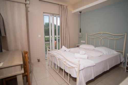 a bedroom with a bed with towels on it at Studios Artemis in Lefkada Town