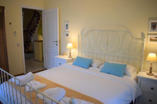 a bedroom with a large white bed with blue pillows at Garitsa Bay Apartment in Corfu Town