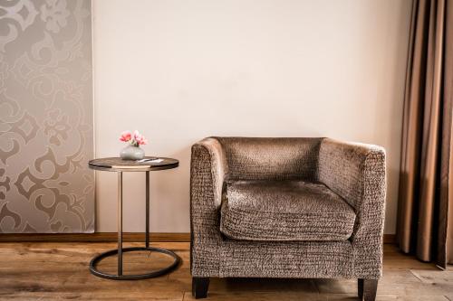 a chair and a table with a vase of flowers at Hotel Restaurant Spa Torkel in Nonnenhorn