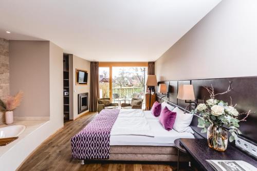 a hotel room with a large bed with purple pillows at Hotel Restaurant Spa Torkel in Nonnenhorn