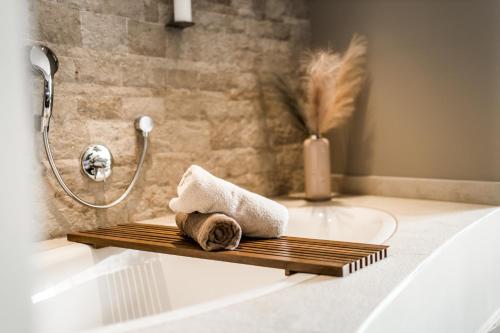 a bathroom with a bath tub with a towel on a shelf at Hotel Restaurant Spa Torkel in Nonnenhorn