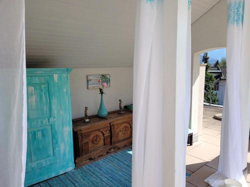 um quarto com uma porta azul e uma cómoda de madeira em Villa Castagna Guesthouse em Lucerna