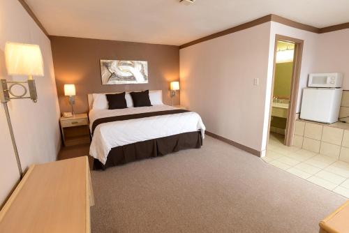 a hotel room with a large bed and a bathroom at Burlington Inn in Burlington