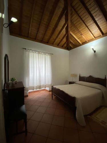 a bedroom with a large bed and a window at Casa da Avó - Turismo Rural in Santo Espírito