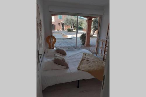 een slaapkamer met een bed en een raam bij Bel appartement dans le Golfe de Saint Tropez in Les Issambres