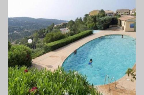 une grande piscine avec une personne dans l'eau dans l'établissement Bel appartement dans le Golfe de Saint Tropez, aux Issambres