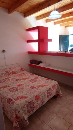 a bedroom with a bed and a red shelf at Dpto PREMA in General Roca