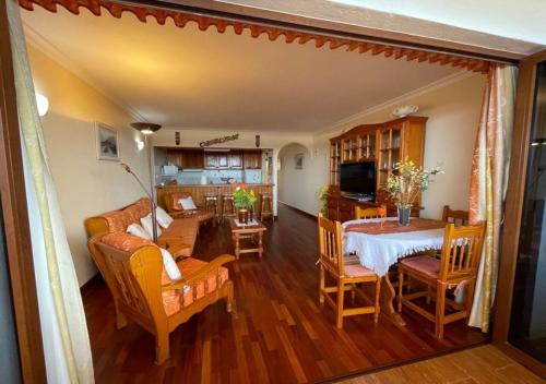 una sala de estar con una mesa y un sofá en Apartamento Neptuno playa 17, en Puerto de Santiago