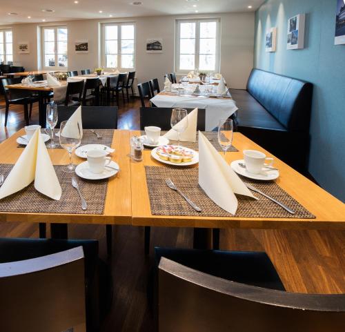 a dining room with a table with plates and glasses at Hotel Kreuz by b-smart in Sachseln