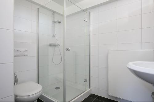 a bathroom with a shower and a toilet and a sink at Lake House 19 relax accommodation in Warmond