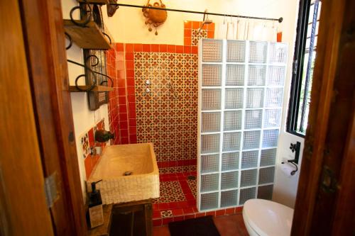 a bathroom with a sink and a red tile wall at Majikal B&B - China Poblana in Cholula