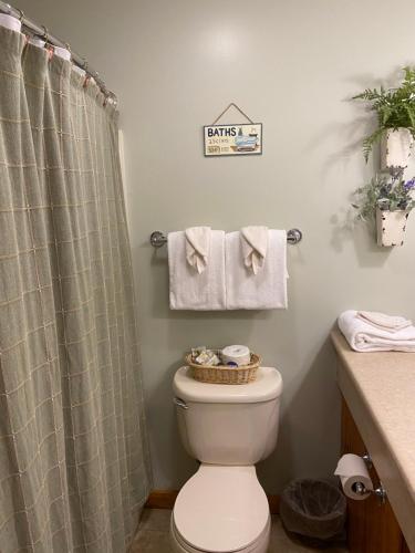 a bathroom with a toilet and a shower curtain at The Garrett Inn in Oakland
