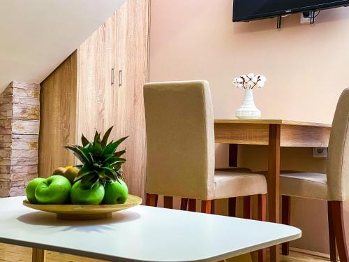 a table with a bowl of green fruit on it at Kiko apartmani in Zrenjanin
