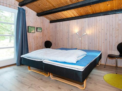 a bedroom with a bed and two chairs in it at Three-Bedroom Holiday home in Rømø 50 in Rømø Kirkeby