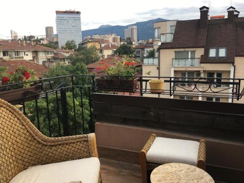 Karina Art Mountain View Apartment في صوفيا: بلكونه فيها كرسيين واطلاله على مدينه