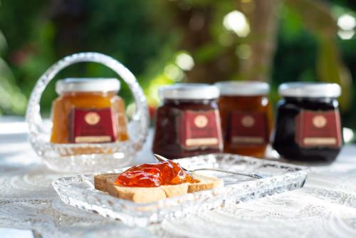 a table with two jars of jam and a piece of bread at Pousada Chalé Suíço in Paraty