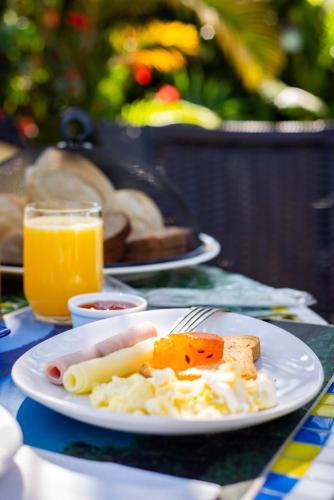 a plate of food on a table with orange juice at Pousada Chalé Suíço in Paraty