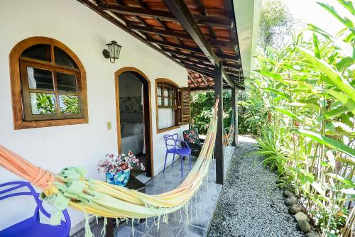 a hammock on the porch of a house at Pousada Chalé Suíço in Paraty