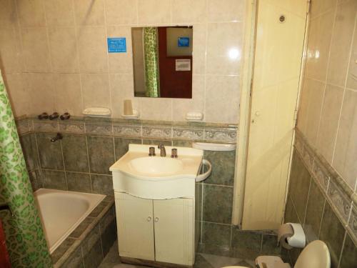 a bathroom with a sink and a tub and a toilet at Hotel Ritz in Villa Carlos Paz